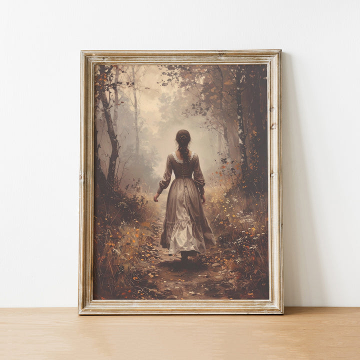 Framed artwork of a woman in a forest on a white wall.