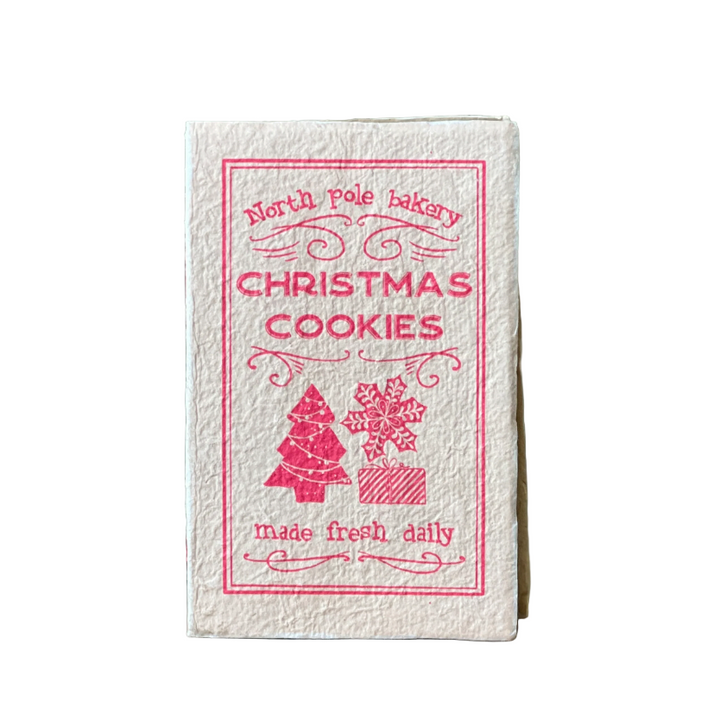 Small book titled 'Christmas Cookies' with decorative text and graphics on a wooden surface.