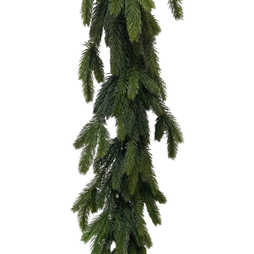 Green artificial garland against a white brick wall