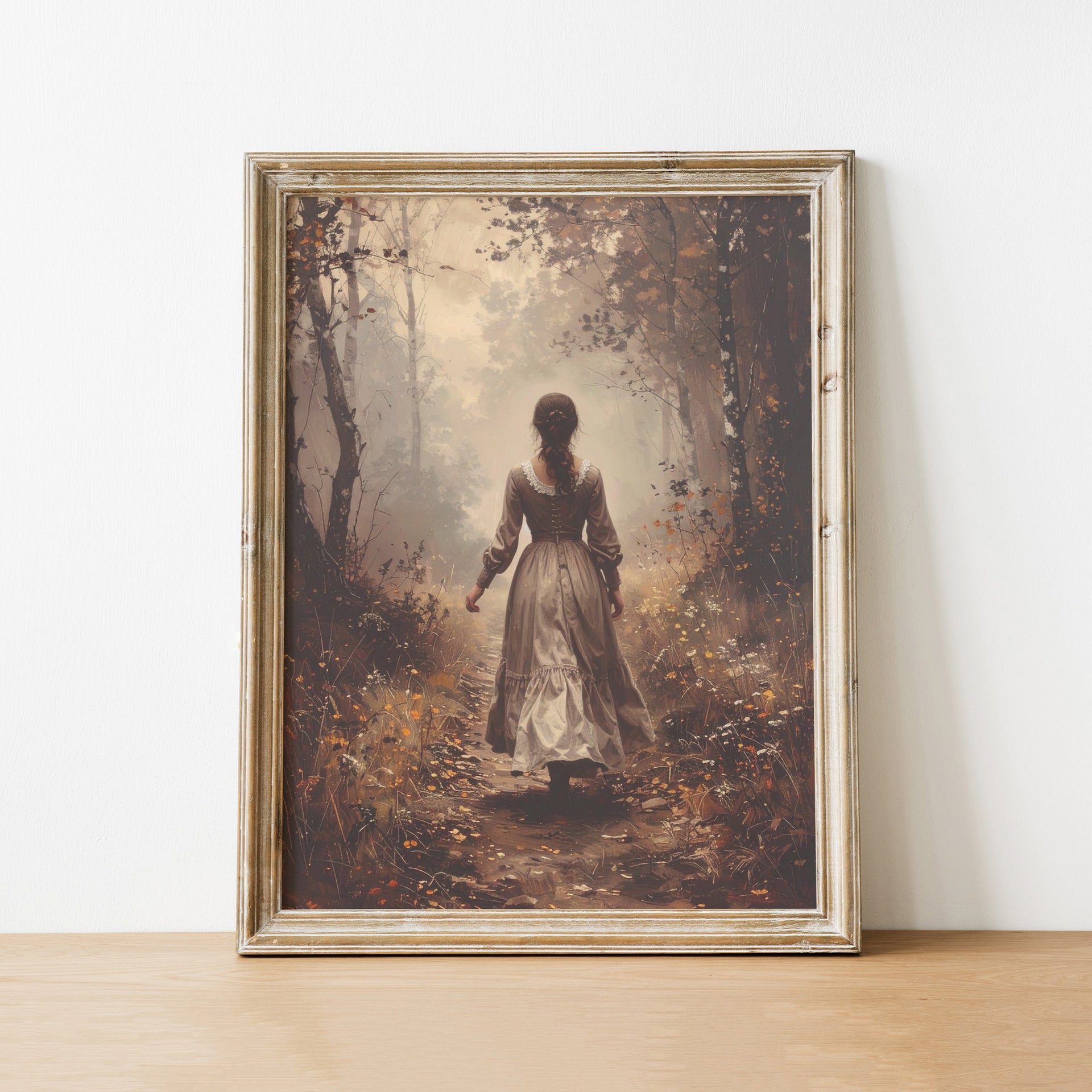 Framed artwork of a woman in a forest on a white wall.