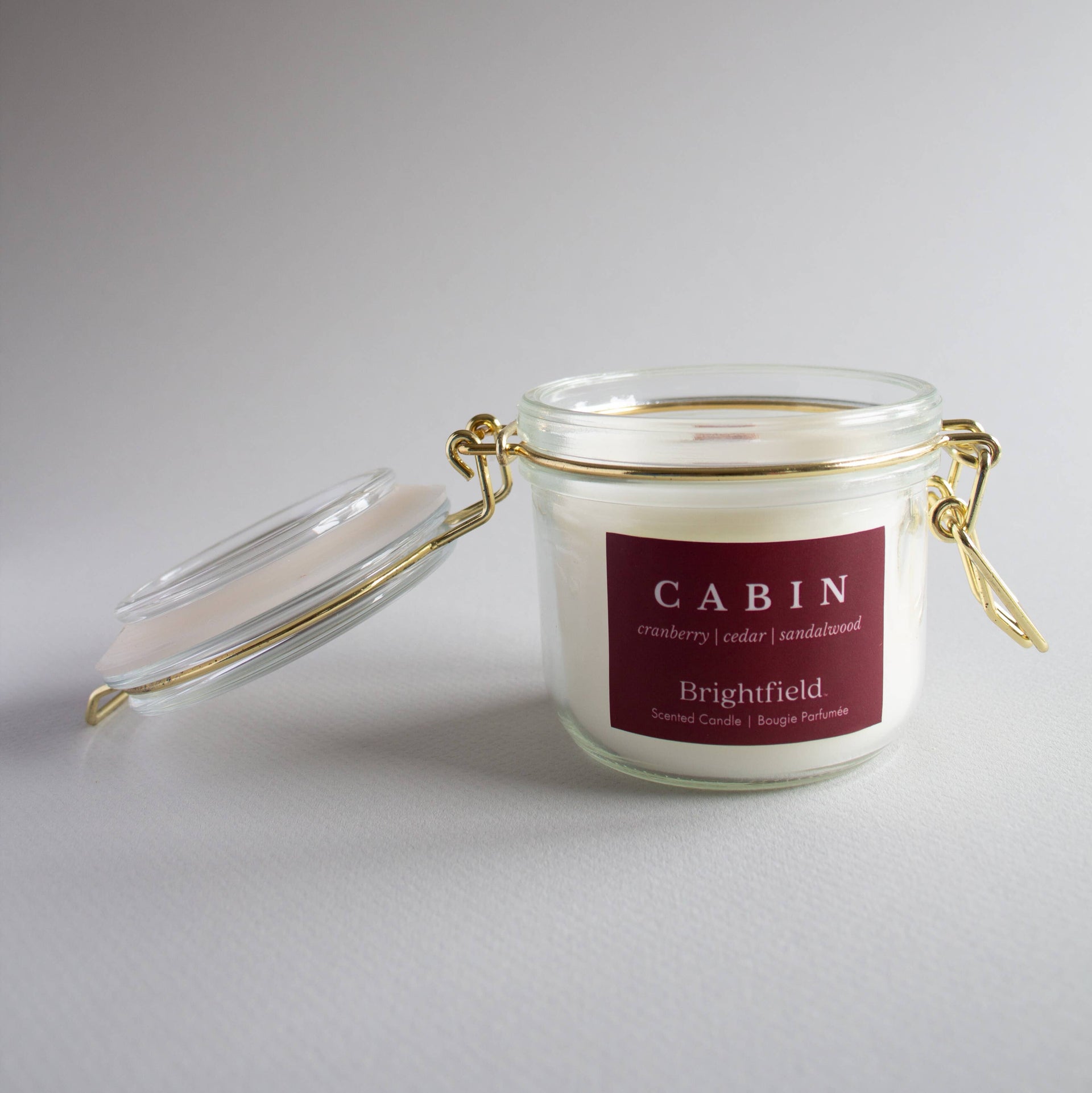 Candle jar with a red label on a gray background