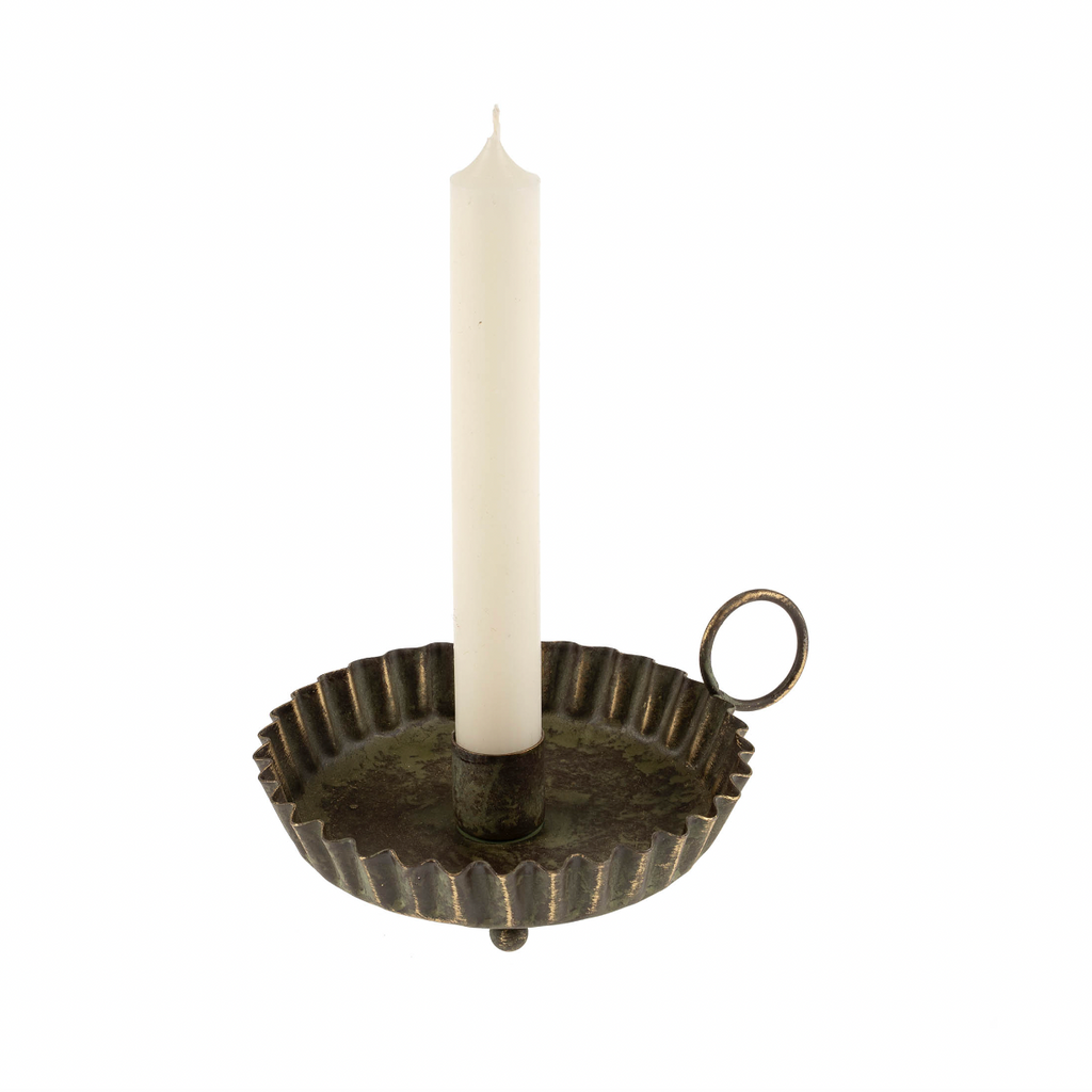 Decorative candle holder with a white candle on a white background